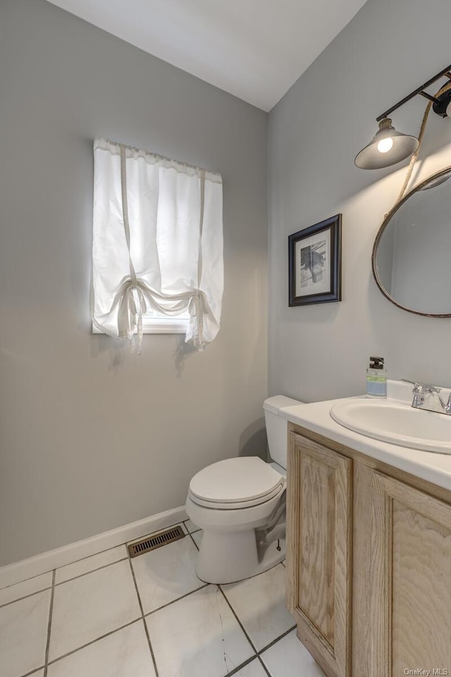 bathroom with tile patterned flooring, vanity, and toilet