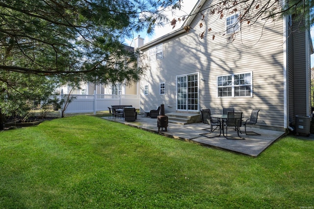 back of house featuring cooling unit, a yard, and a patio