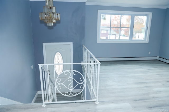 foyer entrance featuring a baseboard radiator, hardwood / wood-style flooring, an inviting chandelier, and crown molding