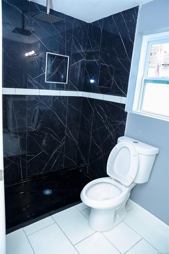 bathroom featuring a tile shower, tile patterned flooring, and toilet