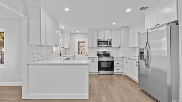 kitchen featuring white cabinets, light hardwood / wood-style floors, sink, and stainless steel appliances