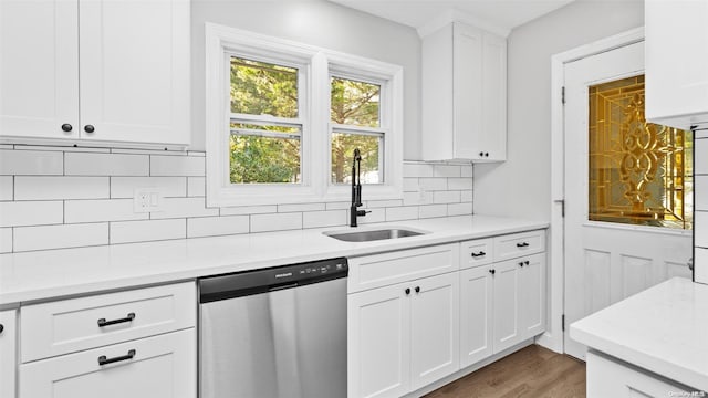 kitchen with backsplash, sink, stainless steel dishwasher, dark hardwood / wood-style floors, and white cabinetry