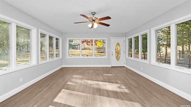 unfurnished sunroom with ceiling fan