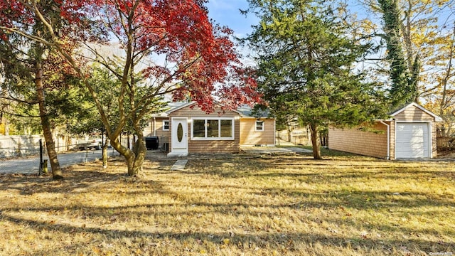 view of front of property featuring an outdoor structure and a front yard