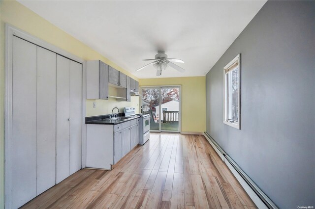 43 2nd St, Ronkonkoma, NY 11779 - kitchen featuring white electric range, a baseboard radiator, a sink, dark countertops, and light wood-type flooring