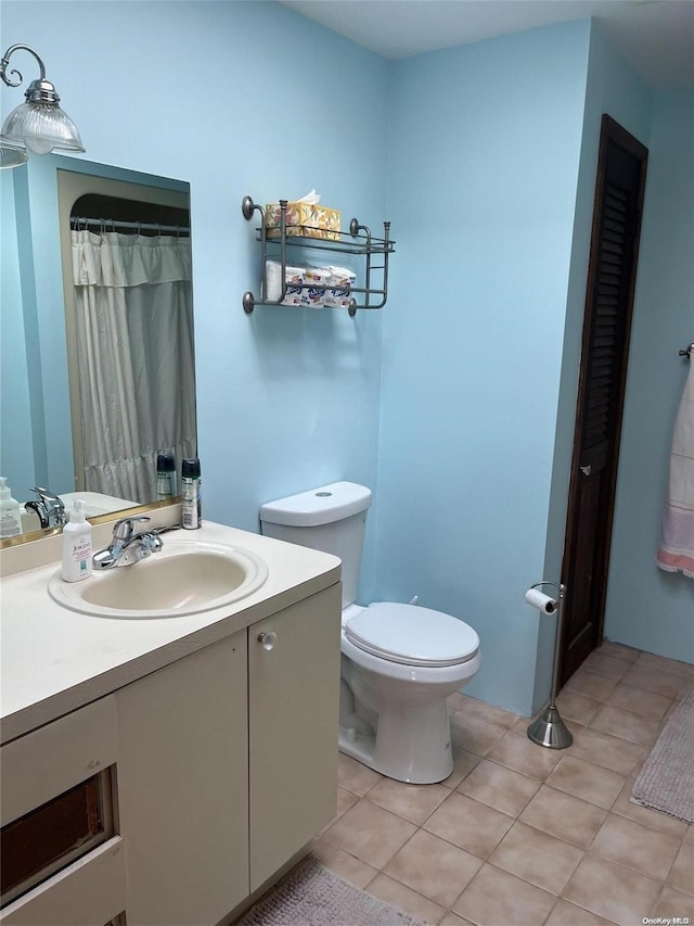 bathroom featuring tile patterned flooring, vanity, and toilet