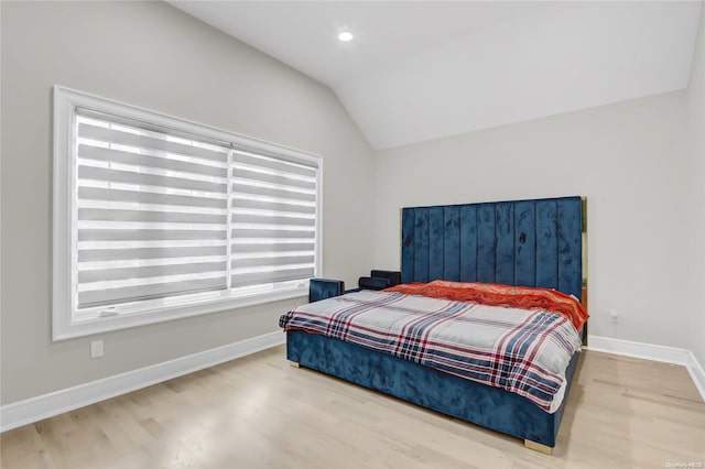 bedroom with wood-type flooring and vaulted ceiling