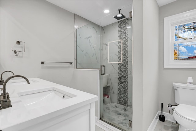 bathroom featuring vanity, a shower with shower door, and toilet