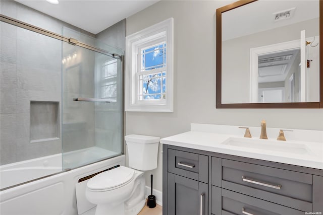 full bathroom featuring vanity, toilet, and bath / shower combo with glass door