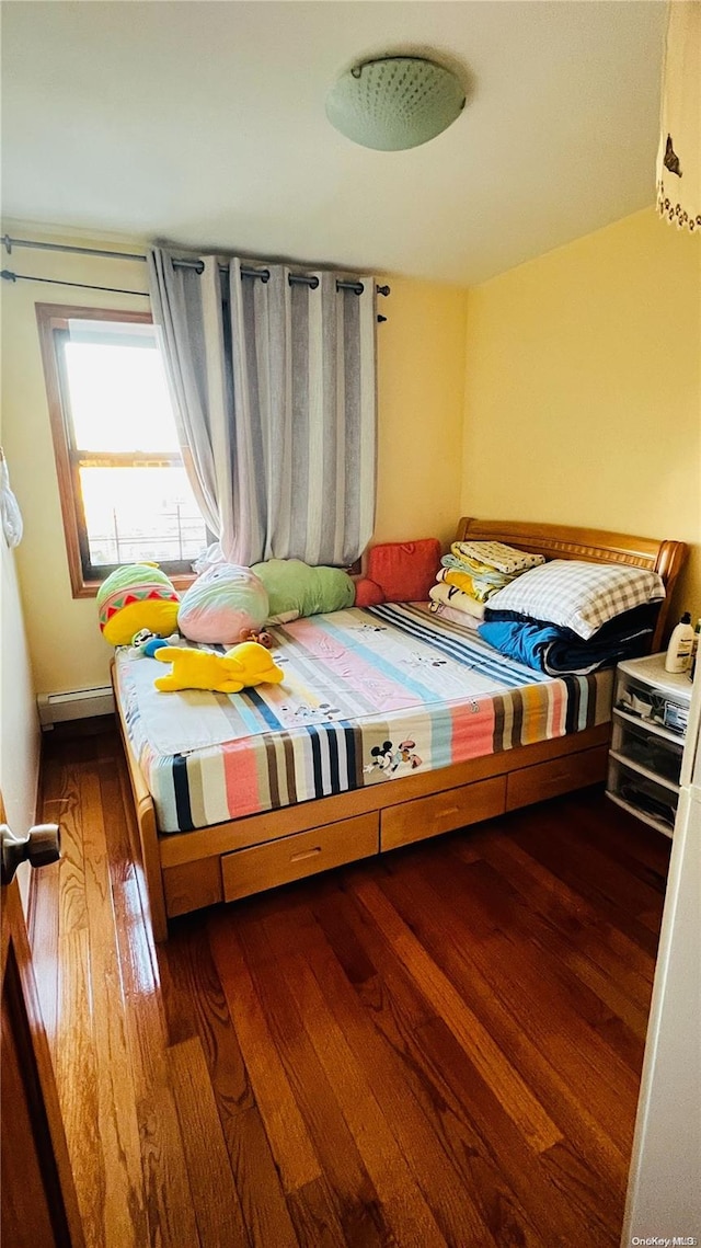 bedroom with dark hardwood / wood-style floors and a baseboard radiator