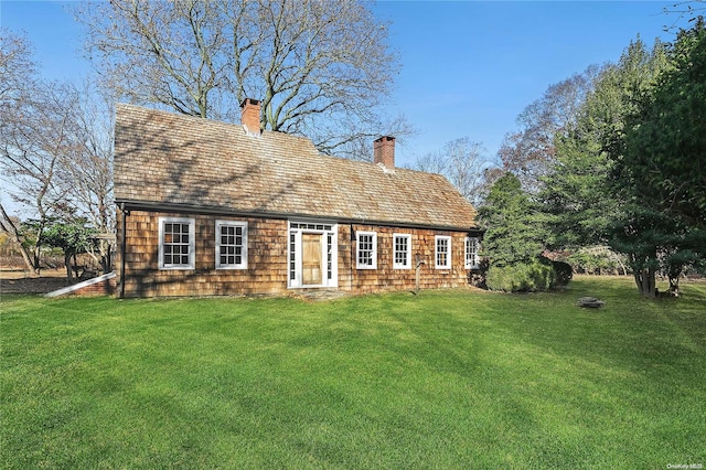 rear view of house featuring a lawn