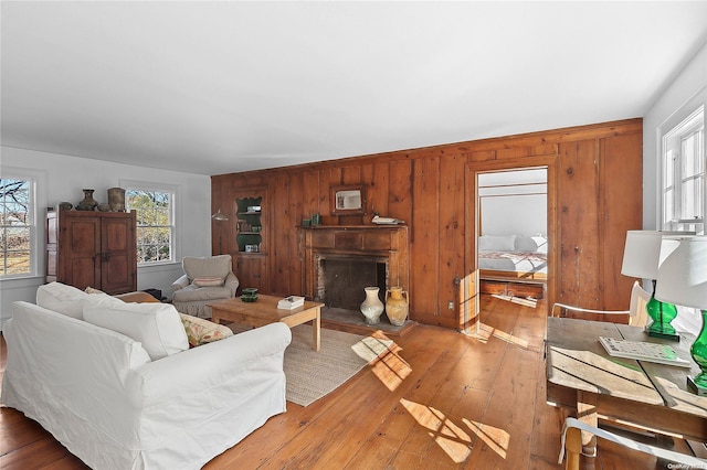 living room with wooden walls and light hardwood / wood-style floors