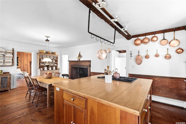 kitchen with a baseboard heating unit, decorative light fixtures, dark wood-type flooring, and a center island