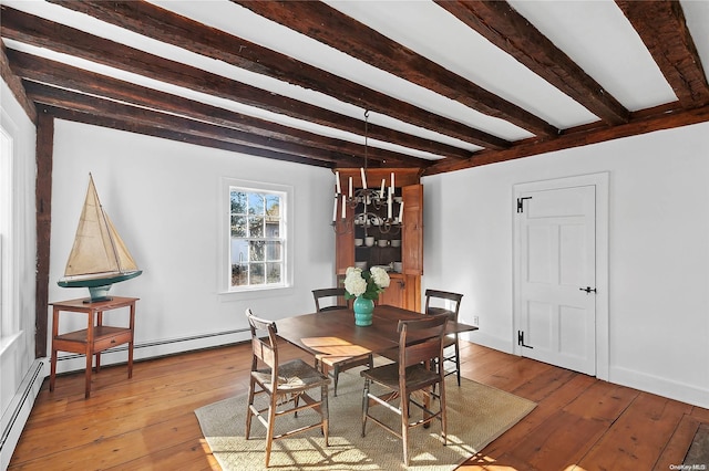 dining space with a baseboard heating unit, beam ceiling, a chandelier, and light wood-type flooring