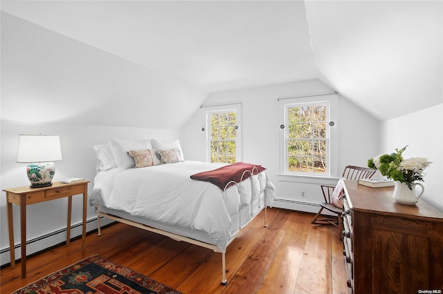 bedroom with lofted ceiling, a baseboard heating unit, and hardwood / wood-style floors