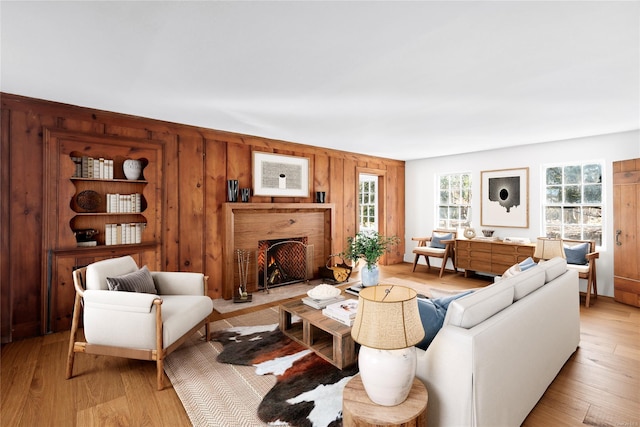 1117 Cedar Ln, East Marion, NY 11939 - living room with wooden walls, a fireplace with flush hearth, and light wood-style flooring