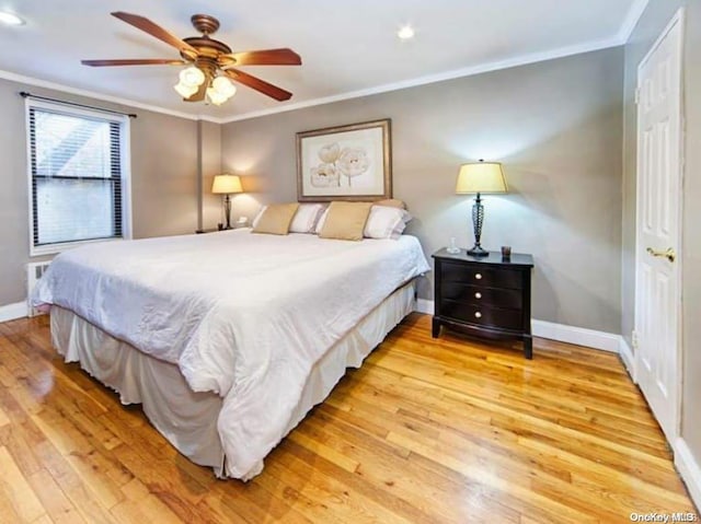 bedroom featuring ceiling fan, light hardwood / wood-style floors, and ornamental molding