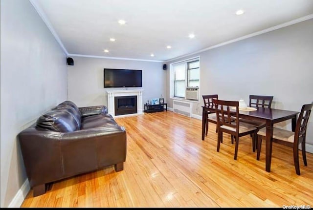 living room featuring radiator heating unit, light hardwood / wood-style flooring, and ornamental molding