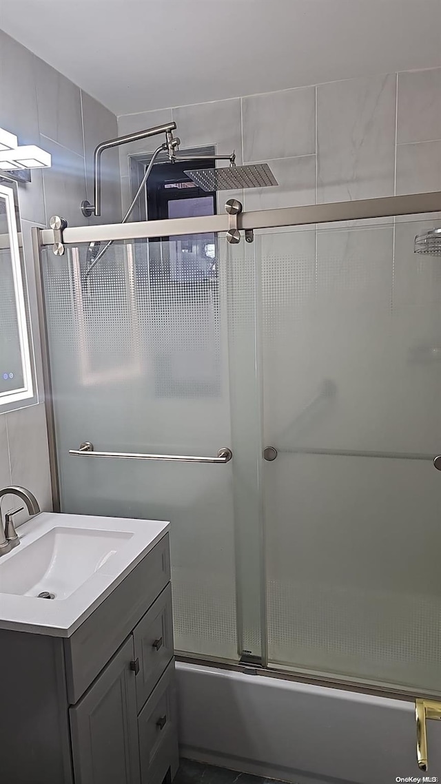 bathroom featuring vanity and bath / shower combo with glass door