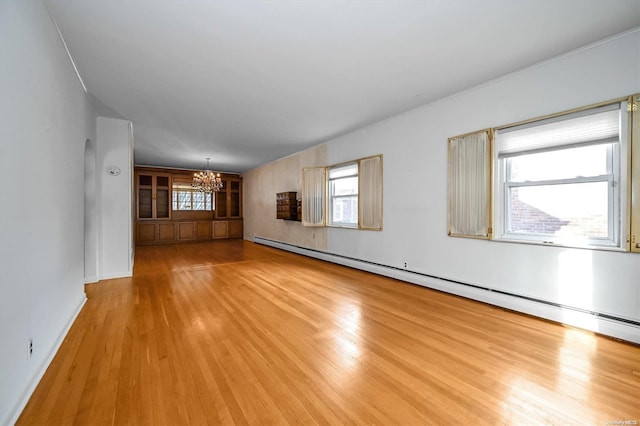 unfurnished room with light hardwood / wood-style flooring, a baseboard radiator, and an inviting chandelier