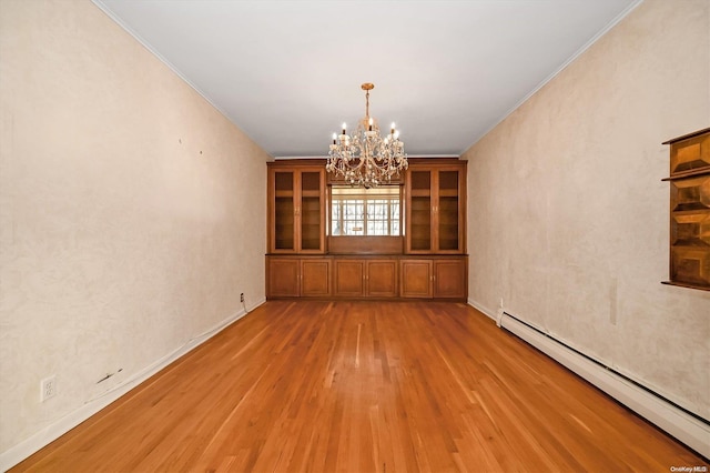 unfurnished dining area with a notable chandelier, crown molding, baseboard heating, and light hardwood / wood-style flooring