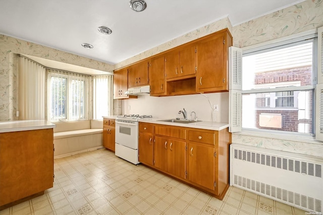 kitchen with white range with gas cooktop, radiator heating unit, and sink