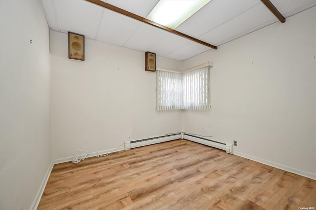 spare room featuring light hardwood / wood-style flooring and a baseboard heating unit