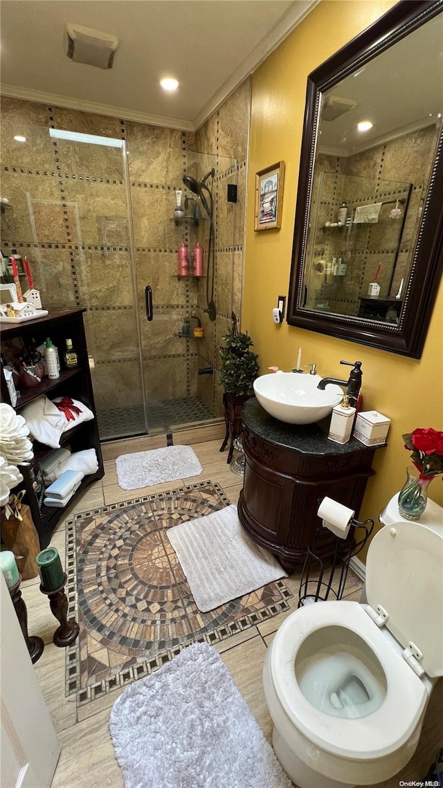 bathroom featuring vanity, an enclosed shower, and ornamental molding