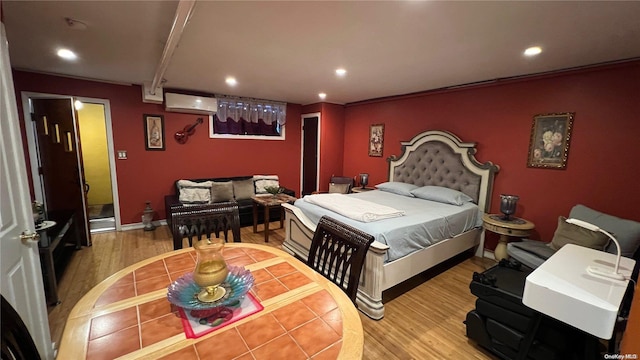 bedroom with a wall mounted AC, hardwood / wood-style floors, and ornamental molding