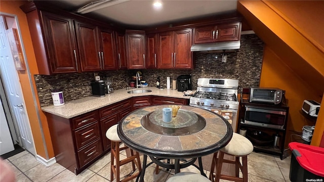 kitchen with decorative backsplash, sink, light tile patterned floors, and stainless steel appliances