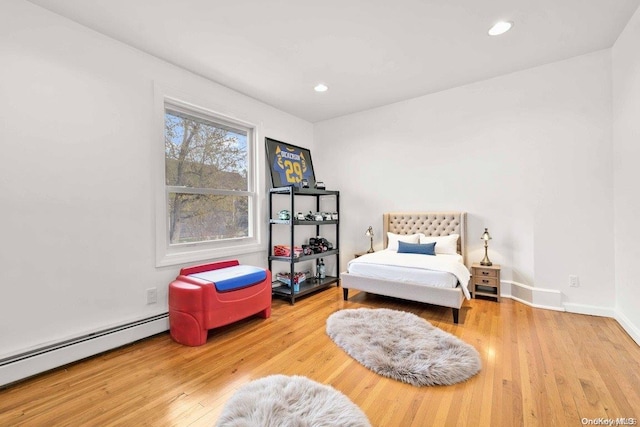 living area featuring hardwood / wood-style flooring and a baseboard heating unit