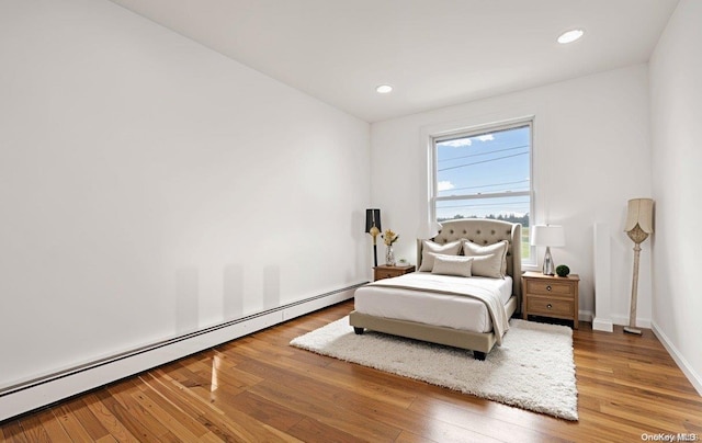 bedroom featuring a baseboard radiator and hardwood / wood-style flooring