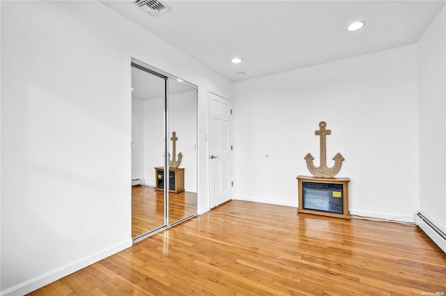 interior space with hardwood / wood-style floors and baseboard heating