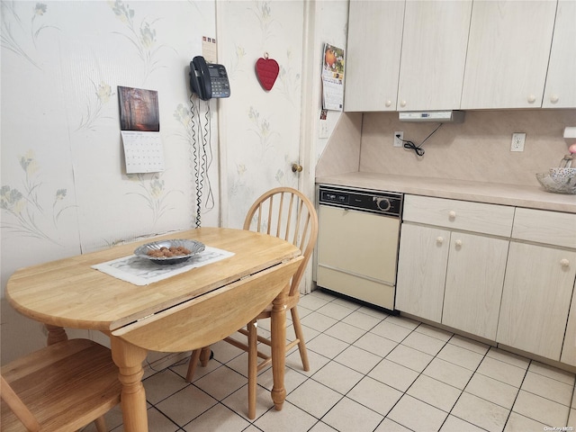 kitchen featuring wallpapered walls, light tile patterned floors, white dishwasher, and light countertops