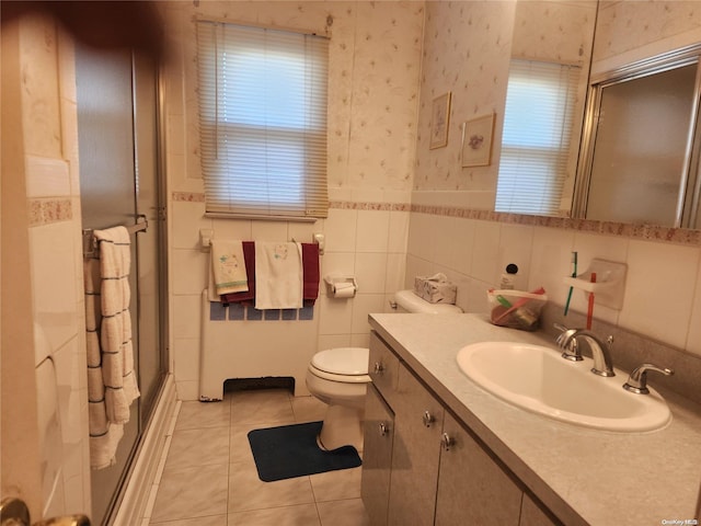 bathroom with wallpapered walls, toilet, tile patterned floors, vanity, and tile walls