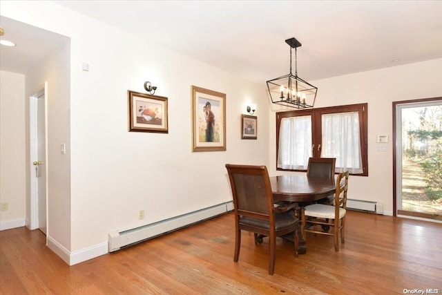 dining room featuring hardwood / wood-style flooring, a notable chandelier, and a baseboard radiator