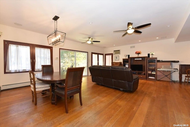 dining area featuring hardwood / wood-style floors and ceiling fan with notable chandelier