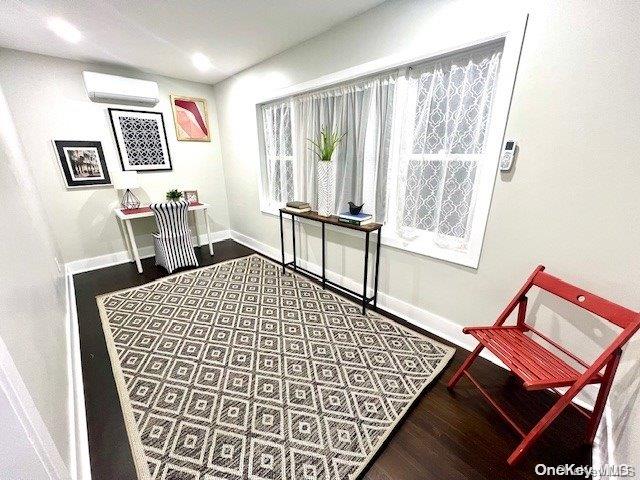 interior space featuring a wall mounted air conditioner and hardwood / wood-style floors