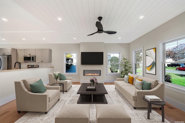 living room featuring ceiling fan, light hardwood / wood-style flooring, and wood ceiling