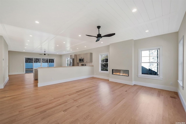 unfurnished living room with ceiling fan, wooden ceiling, and light wood-type flooring