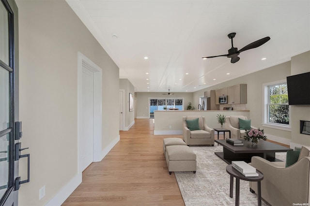 living room with ceiling fan and light hardwood / wood-style floors