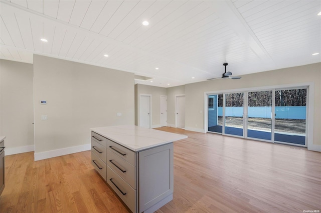 kitchen featuring ceiling fan, light stone counters, light hardwood / wood-style floors, a kitchen island, and wood ceiling