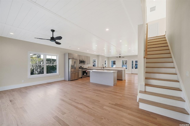 kitchen with ceiling fan, light hardwood / wood-style floors, a center island with sink, wood ceiling, and appliances with stainless steel finishes