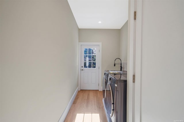 laundry area with washer and dryer and light hardwood / wood-style flooring