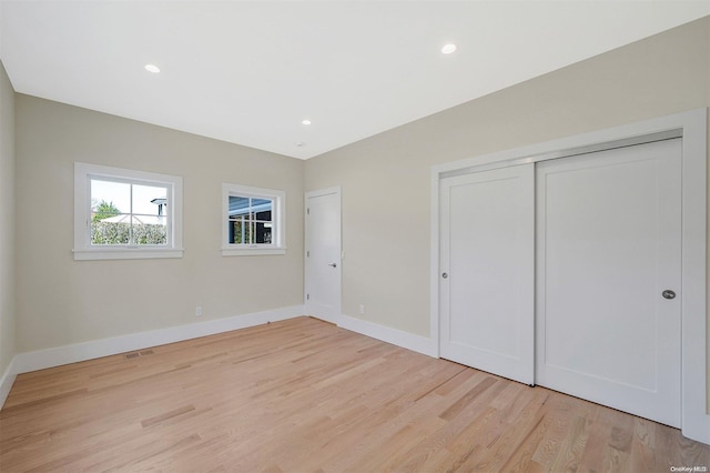 unfurnished bedroom with light hardwood / wood-style floors and a closet