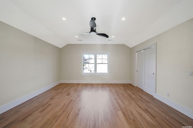 unfurnished bedroom with a closet, light hardwood / wood-style floors, vaulted ceiling, and ceiling fan