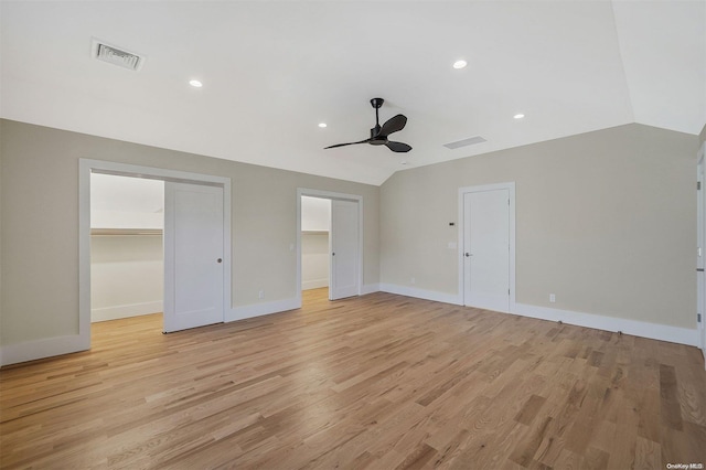 unfurnished bedroom with ceiling fan, light hardwood / wood-style floors, lofted ceiling, and a spacious closet