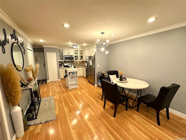 dining room with a chandelier, light hardwood / wood-style floors, and ornamental molding