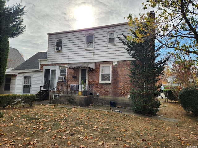 view of property featuring cooling unit and a front yard