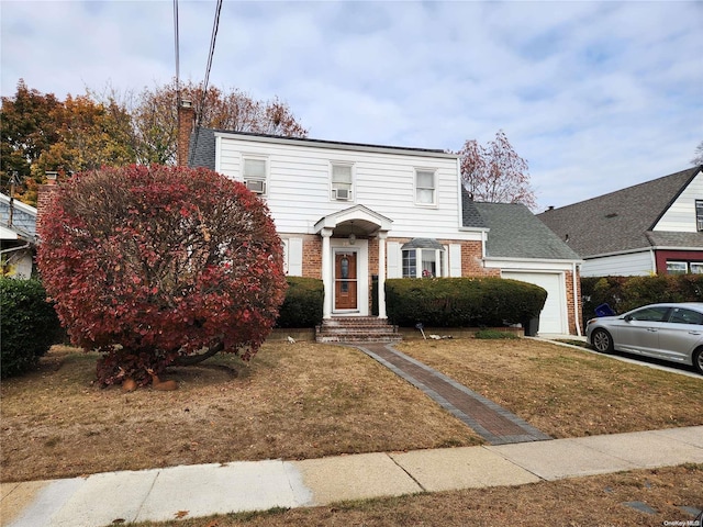 27 Allen St, Hempstead, NY 11550 - view of front of house with a garage, brick siding, a front lawn, and a chimney